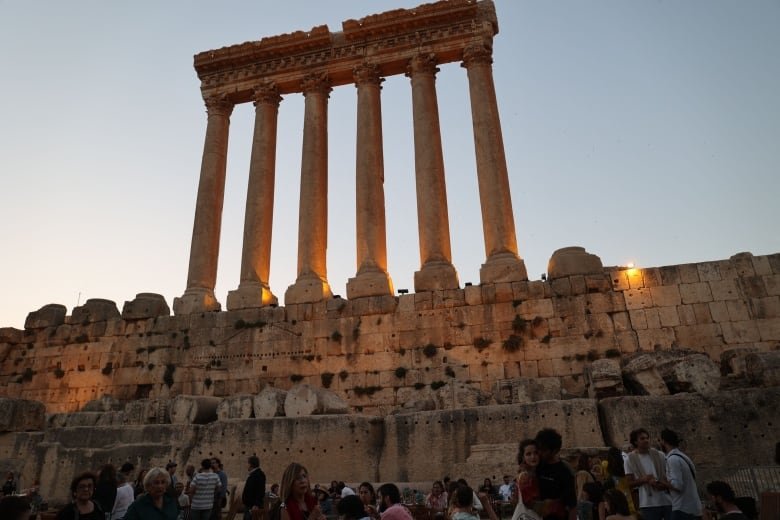 People are seen gathering near the Roman ruins of the Temple of Jupiter.