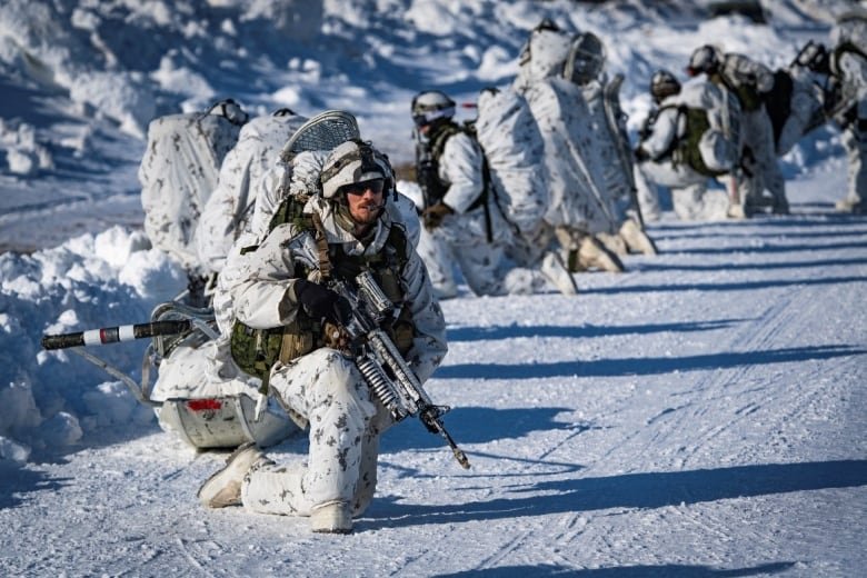 Canadian Army soldiers from 3rd Battalion, Royal 22e Régiment, prepare to move out from a landing area after disembarking from a CH-147 Chinook helicopter in the training area of Fort Greely, Alaska, United States, during training at the Joint Pacific Multinational Readiness Center on March 16, 2022.