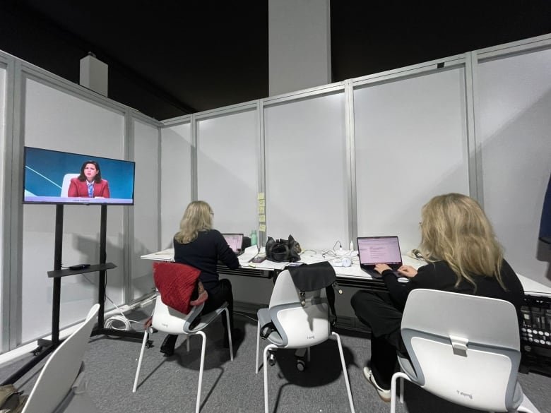 A windowless room with chairs and a screen on the left.