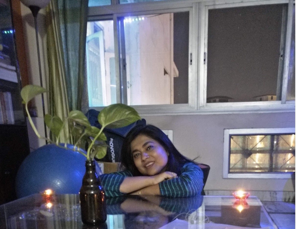 default-423 A woman sits at a clear kitchen table, with large windows in the background.